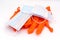Single use medical masks and orange disposable latex gloves