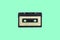 single vintage audio cassette on a green background