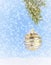 A single, vintage Christmas ornament hanging from a branch of Christmas tree above artificial snow on a blue background.