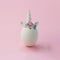 Single white egg, with unicorn decoration; Creative minimal Easter background