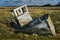 Single white rowing boat stuck on mud flats