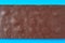 Single whole dark porous chocolate bar lies on blue table on kitchen. Top view