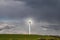 A single wind turbine generating power in a field in rural Cambridgeshire