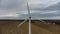 A single wind turbine generating power in a field in rural Suffolk