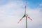 Single windmill generating electricity against blue sky.Beautiful wind turbine on blue sky clouds background