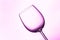 Single wine glass in pink purple lighting
