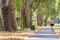 Single woman running along an alley on a grey bike road