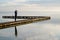 Single woman standing on wooden pier pontoon access boat in Biscarrosse lake sunrise