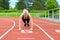 Single woman stretching calf muscles at race track