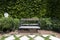 Single wooden bench chair with stone grid walkway pavement and pebble or gravel in exterior garden