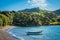 A single wooden row boat moored on an empty sand beach.