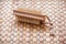 Single wooden scrubbing bath brush on wicker mat