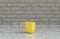 Single yellow coffee mug on a front view kitchen counter top with gray tiled brick wall, 3d Rendering, close-up view