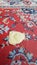 Single yellow leaf atop ethnic woven rug surface