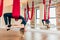 Single yogi woman doing aerial yoga practice in purple hammock in fitness club.