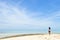 Single young Asian girl walking on tropical white sand beach