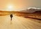 Single young woman with backpack walk on the dirt road towards a mountain ridge. Backpackers style