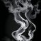 a singular intricately flowing different colored smoke stream against either a black or white background.