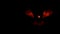 Sinister Halloween pumpkin flickers red infernal light in the dark