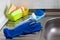 On the sink in the kitchen are colorful and necessary items for washing and cleaning