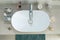 Sink wash basin and personal hygiene items such as toothbrushes, soap, towel in the bathroom