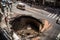 sinkhole opening in the middle of a busy city street, disrupting traffic and bringing chaos