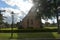 Sint Jacobus Church in Renesse, Zeeland, Netherlands with tree and sun