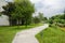 Sinuous footpath in lawn outside building in cloudy summer after