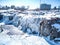 Sioux Falls Park waterfall with ice and snow. Cascading snowmelt water pouring over the top into a pool of standing