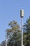 Siren tower rising between trees, against a blue sky, space for text