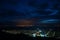 Siria village seen from the Siria Fortress at night. The bright lights of the city Arad in the background.