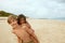 Sister And Brother On Beach. Tanned Siblings Enjoying Summer Vacation On Coast. Positive Boy And Girl Covered With Sand.