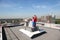 Sister, brother with camera standing on roof