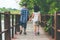 Sister and brother hand in hand walking together in Wood bridge