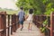 Sister and brother hand in hand walking together in Wood bridge