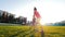 Sister and brother hold hands and cheerfully jump on the grass with puddles. Flying spray, children laugh.