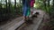 Sister brother and mother walk through narrow board. Active children with mom