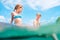 Sister and brother sitting on  inflatable mattress and enjoying the sea water, have fun when swim in the sea. Careless childhood