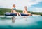 Sister and brother sitting on  inflatable mattress and enjoying the sea water, have fun when swim in the sea with Croatian green