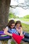 Sister firends girls relaxed under tree park after school