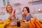 Sister laughing while filming her sibling eating too much sweets