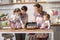 Sisters 1 and 3 years old girls with their mother and grandmother in the kitchen.