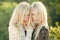 Sisters blonde twins posing on natural landscape. Beauty and fashion. Two women face.