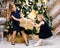 Sisters fighting for wrapped present standing beside decorated christmas tree at home on boxing day