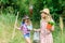 Sisters helping at farm. Girls with gardening tools. Eco farming concept. Adorable girls in hats going planting plants