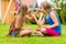 Sisters playing in garden eating strawberries