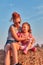 Sisters playing with hay bale together outdoors in the countryside