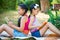 Sisters reading book in summer park