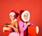 Sisters in Santa Claus hats with gift boxes receive present.