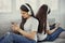 Sisters teenage girls with smart phone and headphones listening music and ommunicate in social networks